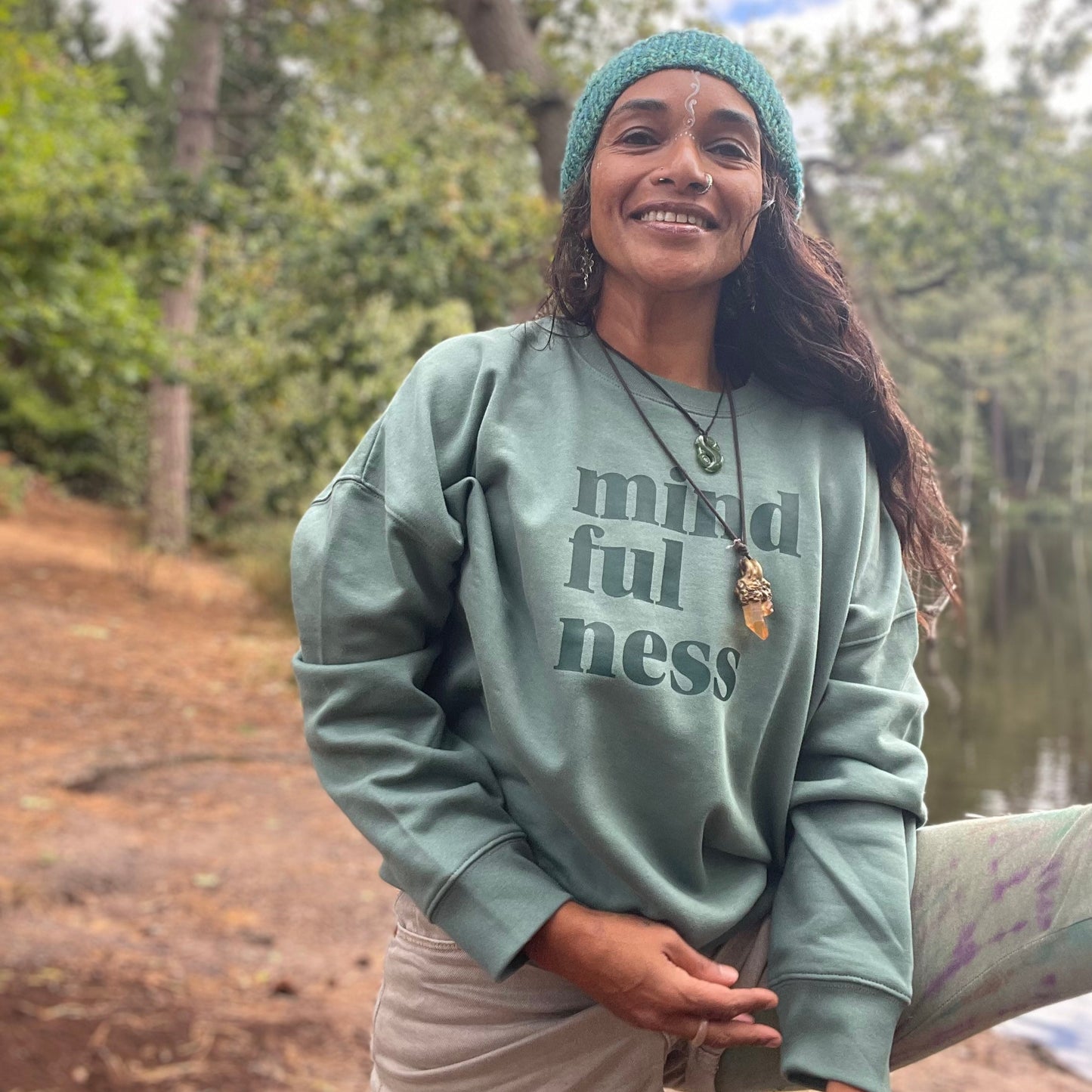 Person wearing a green 'mindfulness' sweatshirt outdoors