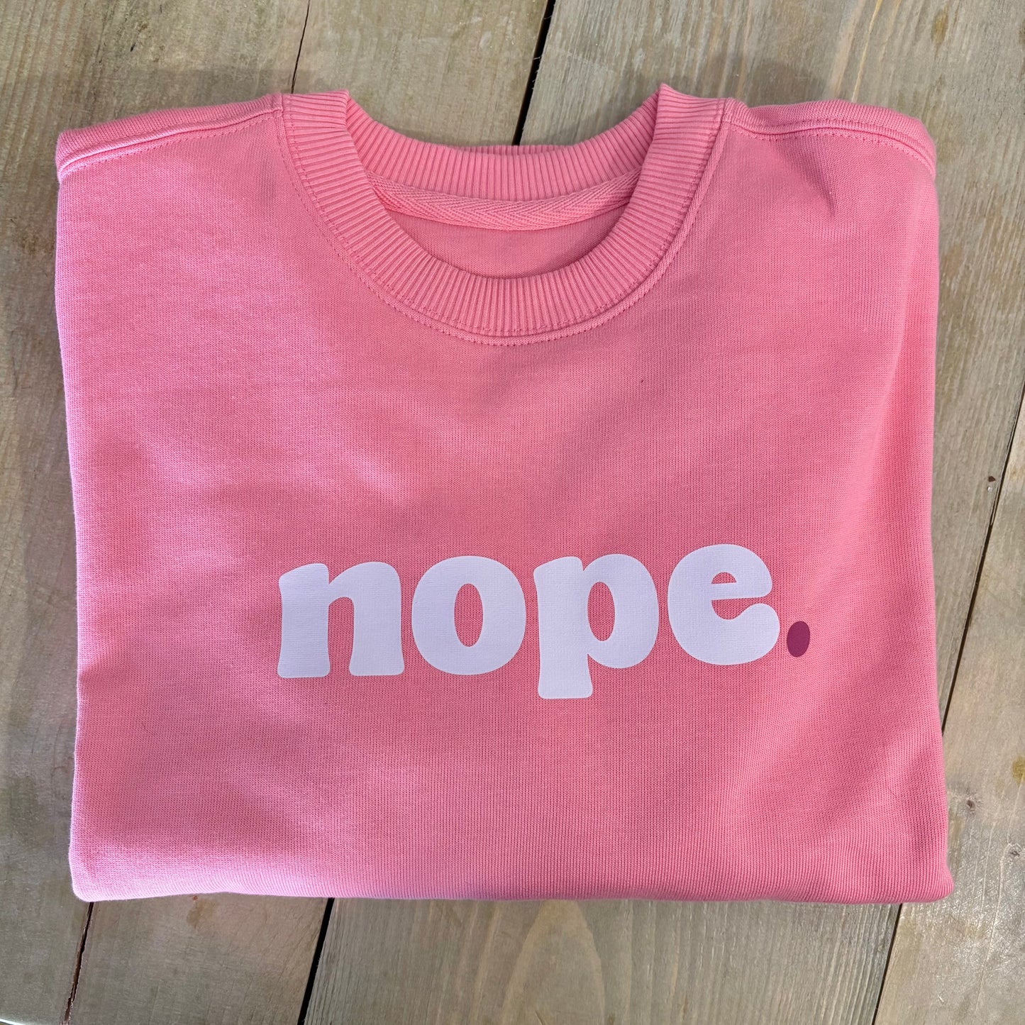 A pink oversized sweatshirt with the word 'NOPE' printed in white on the front by this is mabel