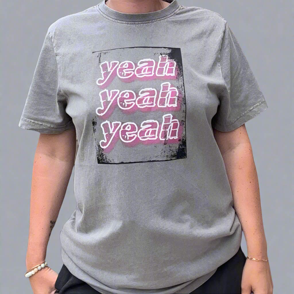 Person wearing a this is mabel grey t-shirt with 'yeah yeah yeah' text design.