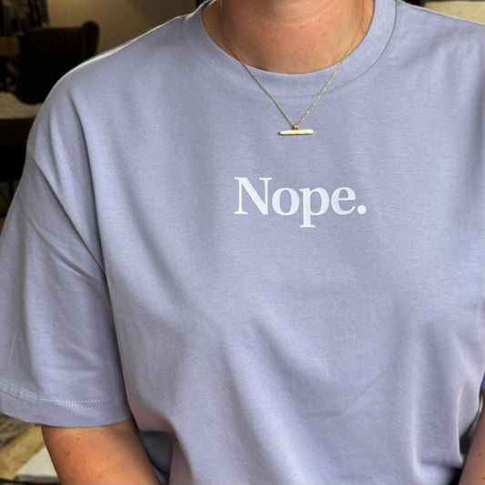 Person wearing a light purple t-shirt with 'Nope.' text.