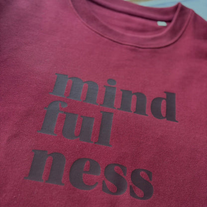 burgundy with 'mindfulness' text on a wooden surface