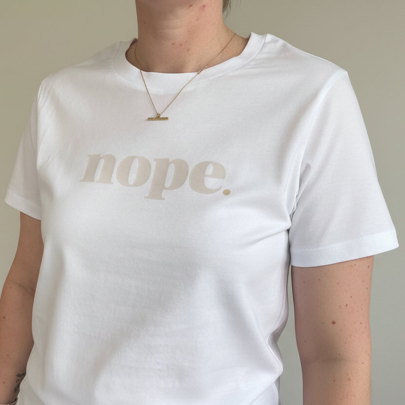 White shirt with 'nope' printed on it worn by a person.