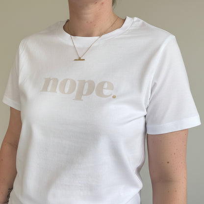 White shirt with 'nope' printed on it worn by a person.