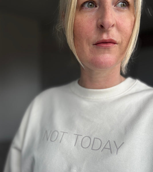 Person wearing a cream this is mabel oversized  sweatshirt with 'NOT TODAY' text.