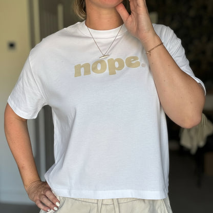 Person wearing a white t-shirt with 'nope' printed on it in a casual setting.