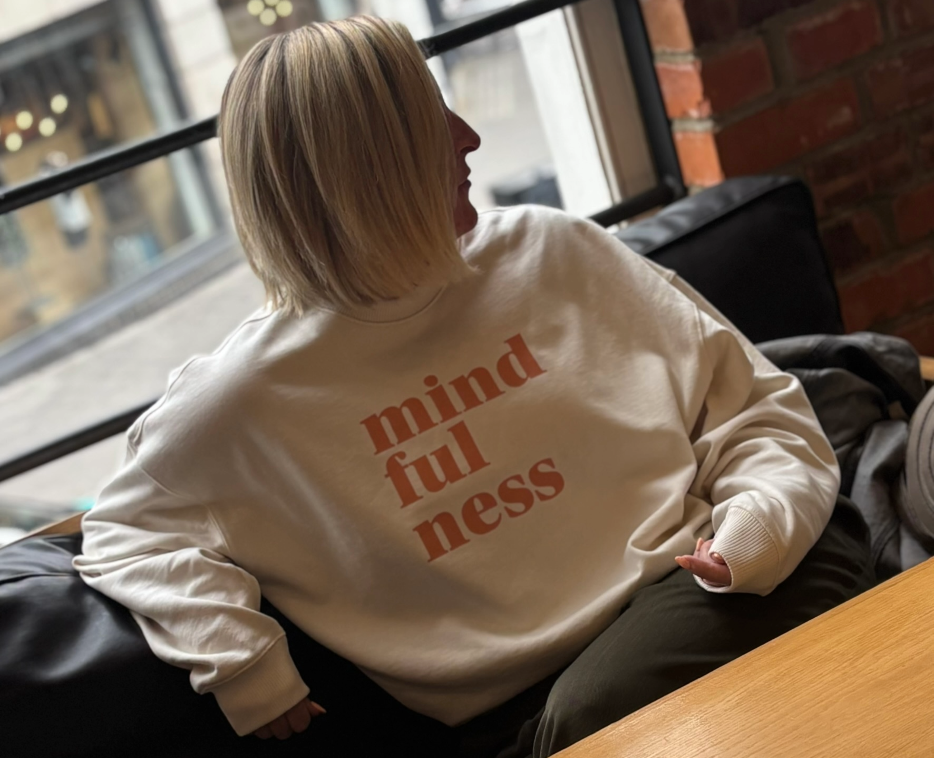Person wearing a cream oversized sweatshirt with 'mindfulness' print this is mabel collection