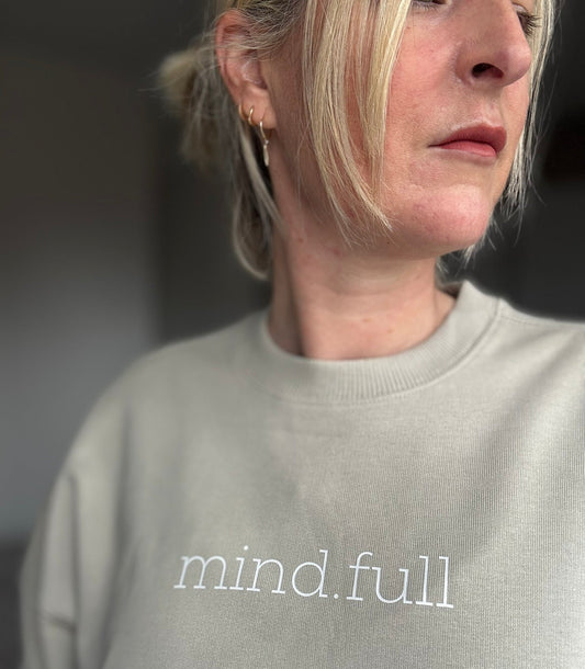 Woman wearing Mindful oversized sweatshirt in cream, printed with ‘mind.full'