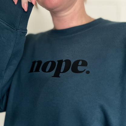 Person wearing a teal sweater with 'nope' printed on it. This is Mabel collection 